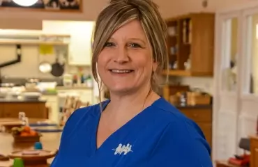 Smiling female nurse in blue scrubs