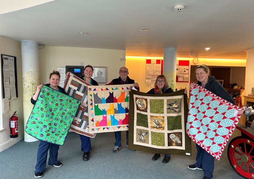 Members of Project Linus hand quilts to care staff at Charlton Farm