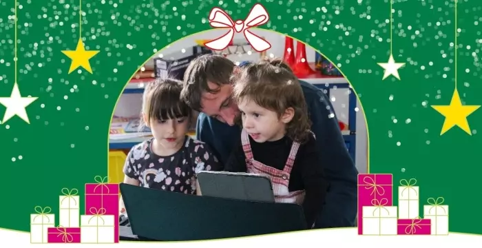 Dad with two daughters at a keyboard with graphic stars and presents