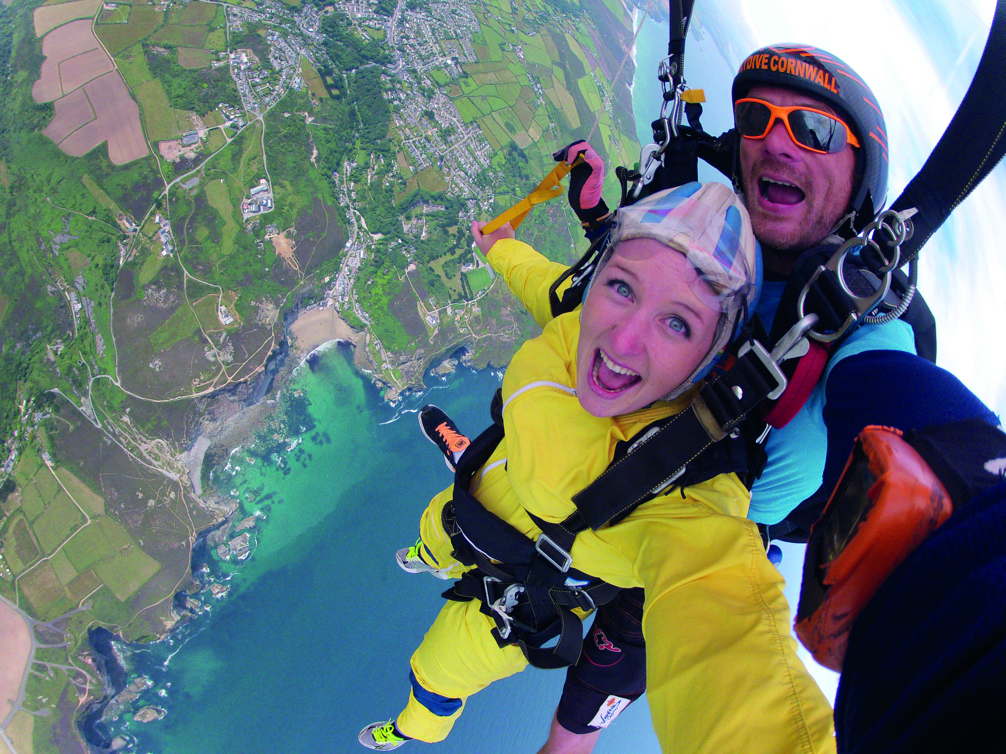 Lady skydiving over Cornish coastline