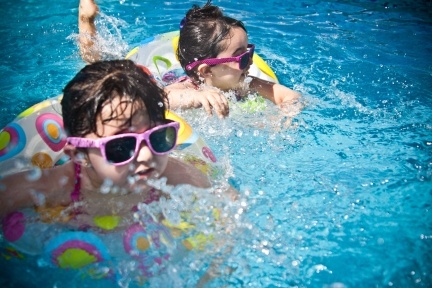 Children splashing in swimming pool with swimming rings