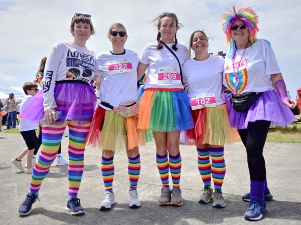 A group of women in white tops and rainbow tutus and accessories