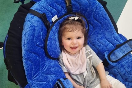 Avery sitting in blue pea pod chair