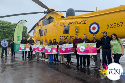 All of the sponsors of this years Rainbow Run Cornwall by a yellow helicopter at RAF St Mawgan