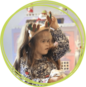 Girl in wheelchair wearing Rudolph christmas antlers