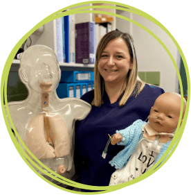 Woman wearing nurse uniform smiling and holding doll