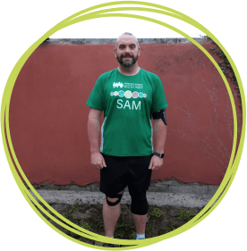 Sam is running the London Marathong Man in green tshirt standing in garden