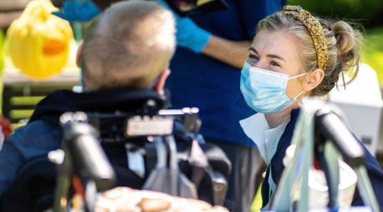 Childrens nurse wearing face mask and talking with patient