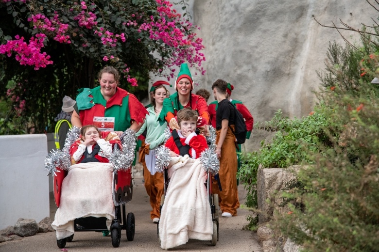 Two children in wheelchairs and their family dressed as elves 