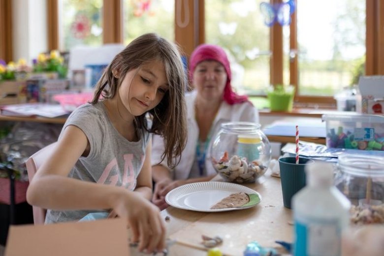 siblings in messy play with carer