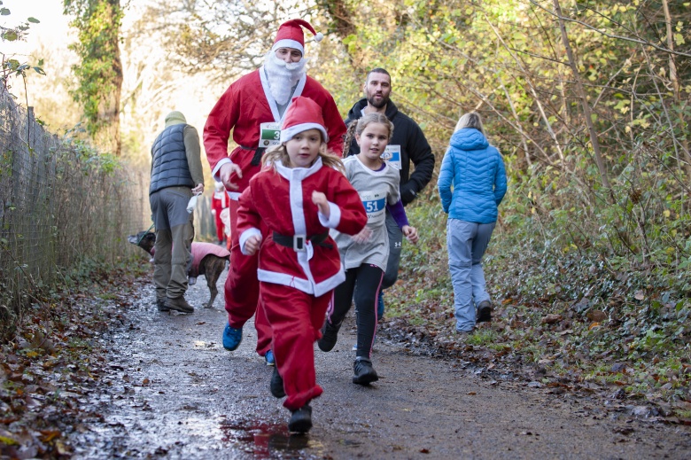 Two people dressed in santas suits running