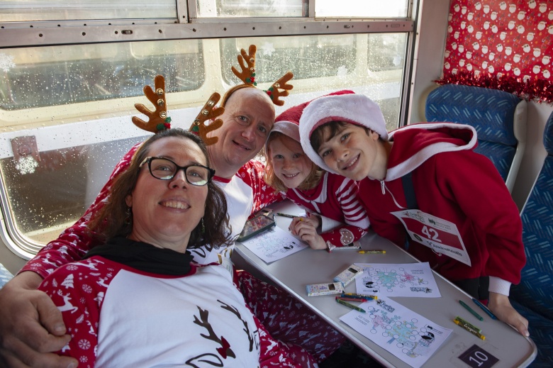 Family in christmas pyjamas on the santa train