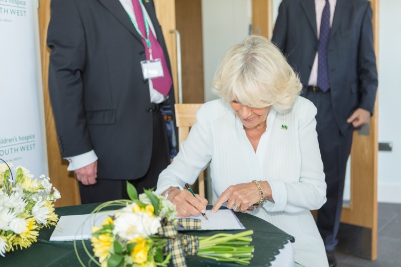 Her Majesty the Queen (formerly HRH The Duchess of Cornwall) signing guest book