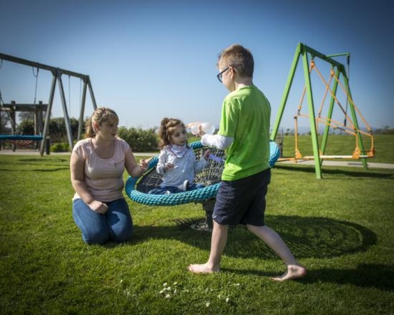 Sibling and carer playing in Little Harbour garden