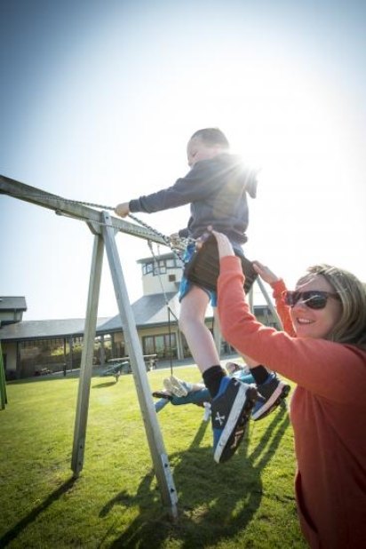 boy on swing with sibling team