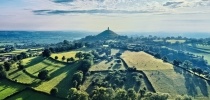 drone shot of Glastonbury Tor in the distance thumbnail