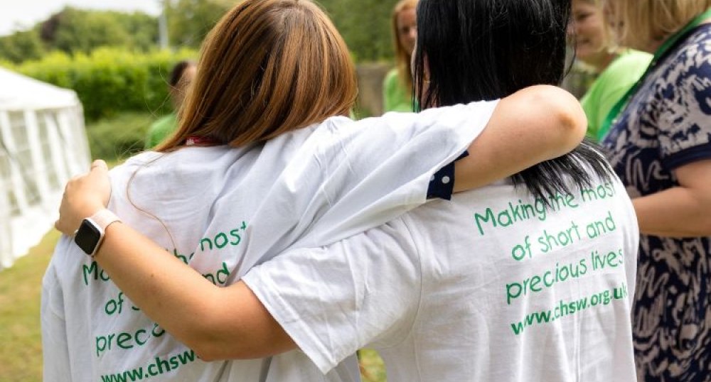 Two women with CHSW tshirts with their arms round each other