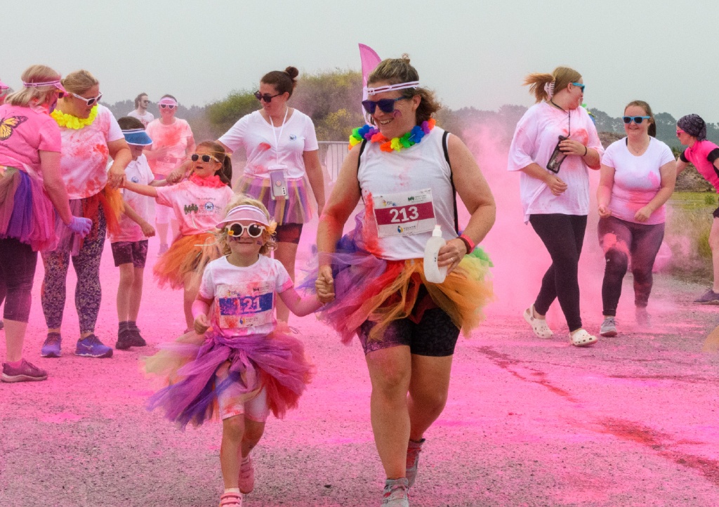 Mum and daughter covered in pink powder paint