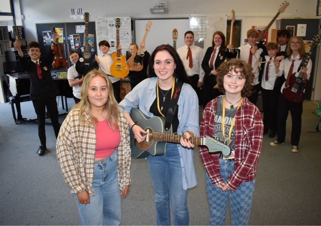 Evie Cloke, Abi Hutchings and Madeleine Marston with some of the young musicians who will perform