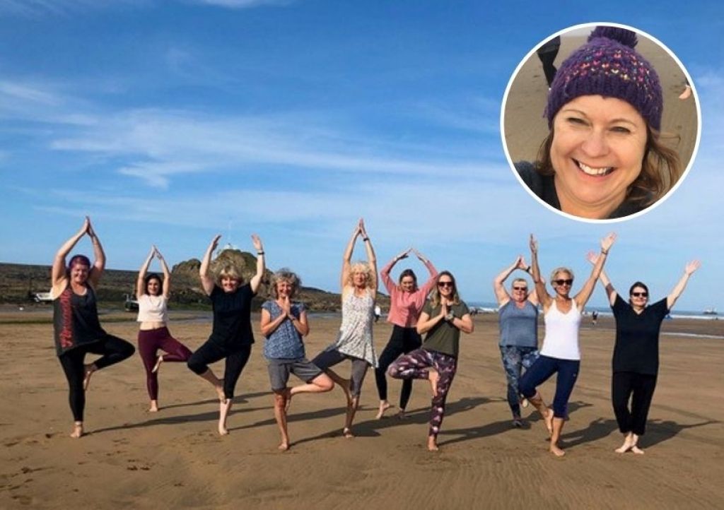Yoga teacher Claire Jennings and students on the beach in Bude