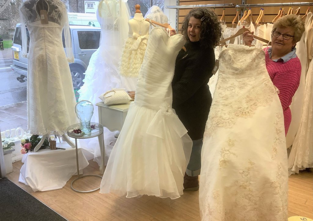 Lynne Whitehall and Emily Thornhill with the wedding dresses in the Honiton CHSW shop