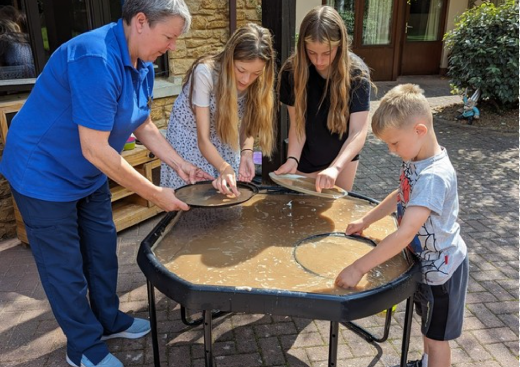 Sibs worker Sally panning for gold with children at LBH