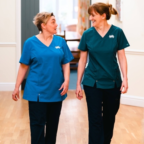 Two nurses walking down a corridor