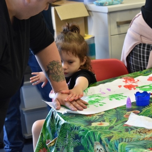 Girl helping mum with hand painting