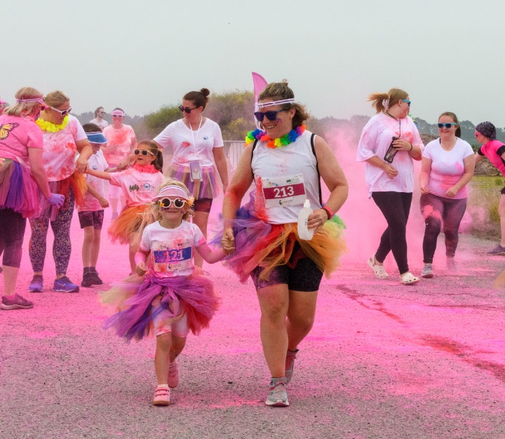 Mum and daughter covered in pink powder paint