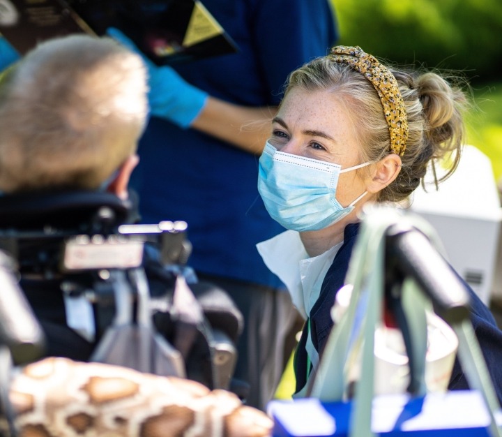 Childrens nurse wearing face mask and talking with patient