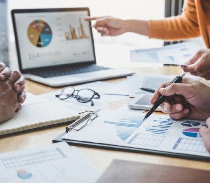 Laptop on desk presenting data as graphs and charts