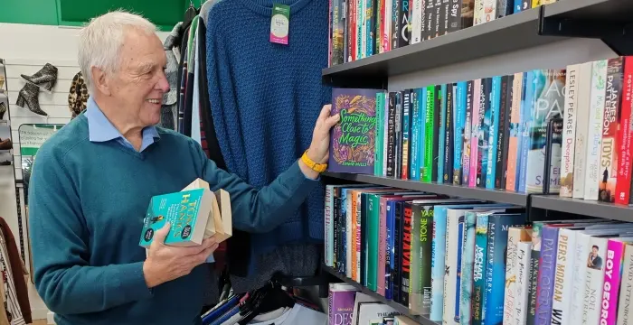 Volunteer stocks books at a charity shop