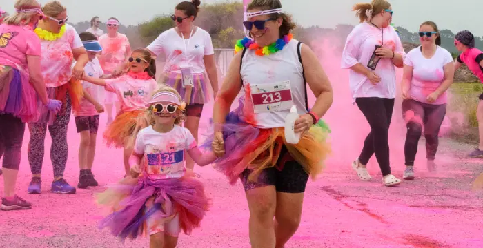 Mum and daughter covered in pink powder paint