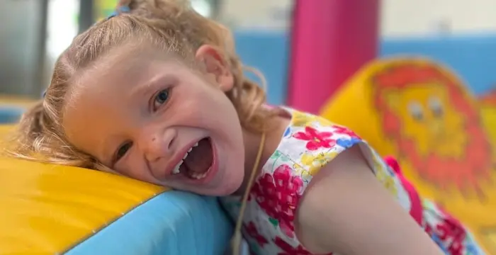 girl lying on soft play smiling