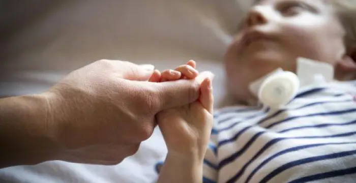 Boy on floor holding hands 