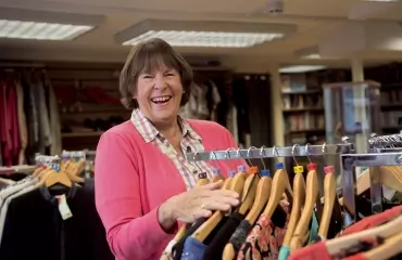 Similing woman volunteering in CHSW charity shop